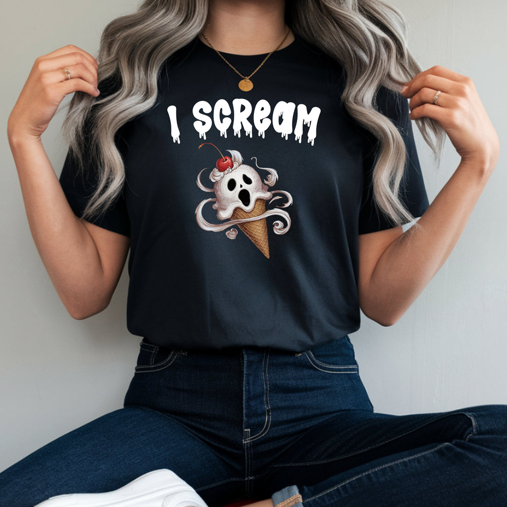 A woman wearing a black graphic t-shirt with a white 'I SCREAM' text and a skull in an ice cream cone design, paired with dark blue jeans and white sneakers, sitting on a red stool.