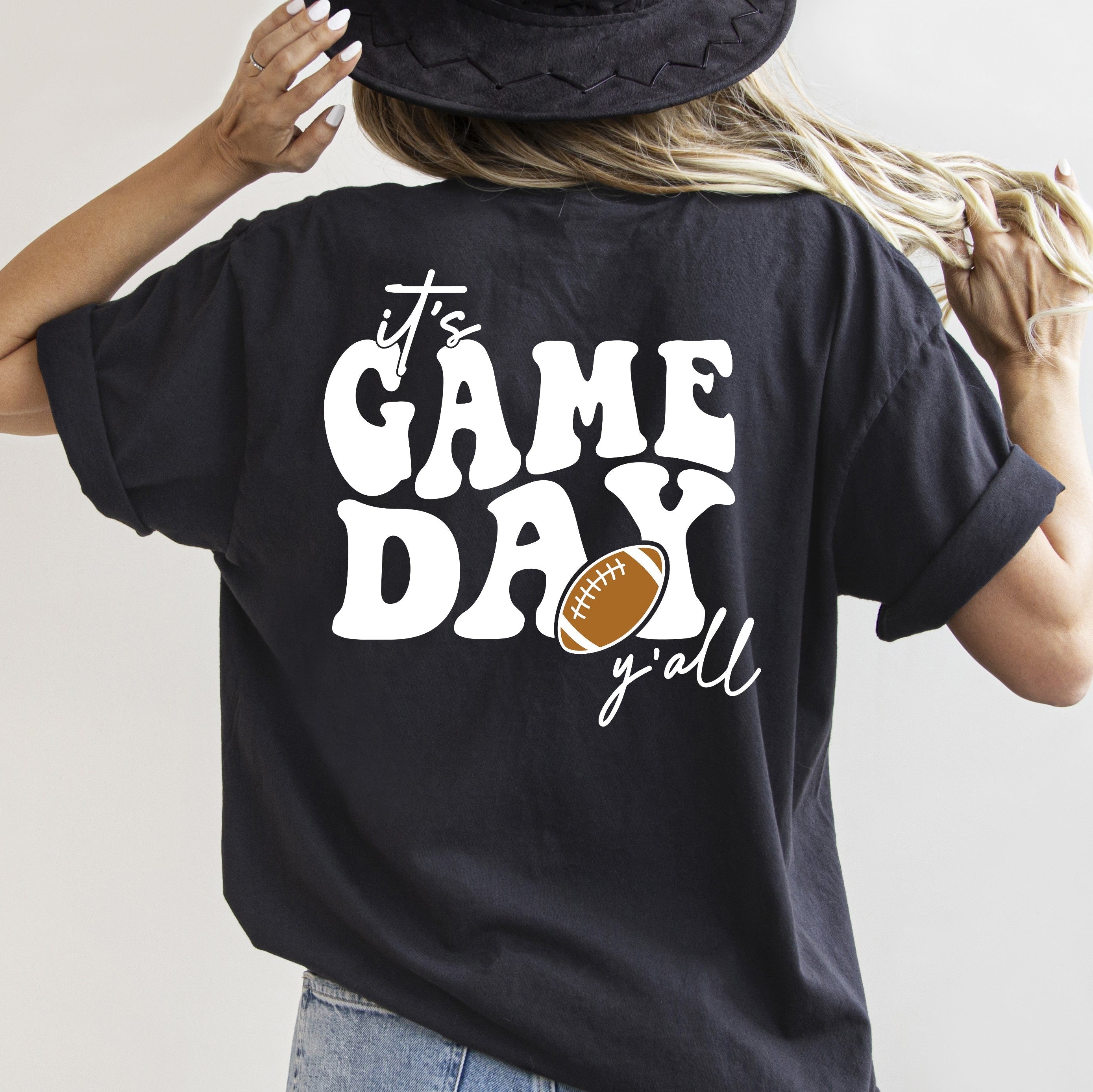 Person wearing a black t-shirt with 'It's Game Day y'all' text and football graphic.
