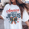 Person wearing a white t-shirt with 'America Needs Jesus' design outdoors.