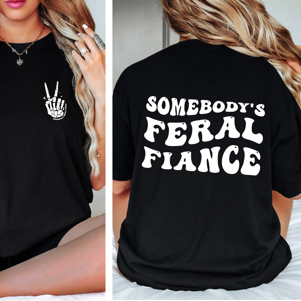 Black t-shirt with a hand gesture on the front and 'SOMEBODY'S FERAL FIANCE' text on the back.