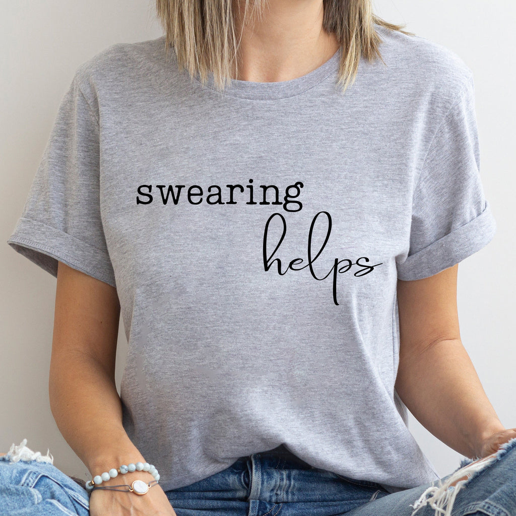 Person wearing a gray t-shirt with 'swearing helps' text.