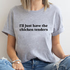 Person wearing a gray t-shirt with text 'I'll just have the chicken tenders' on a plain background