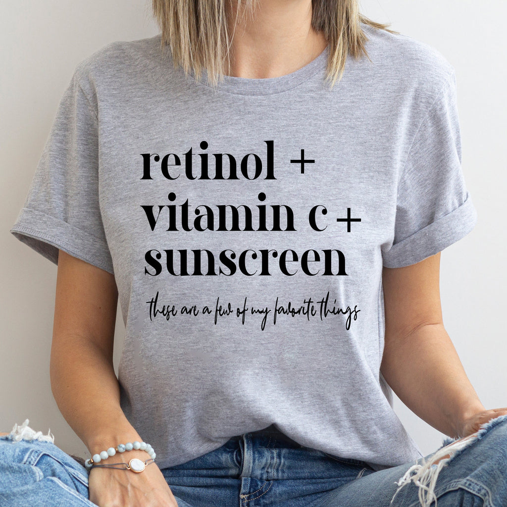 Person wearing a gray t-shirt with text about skincare products.