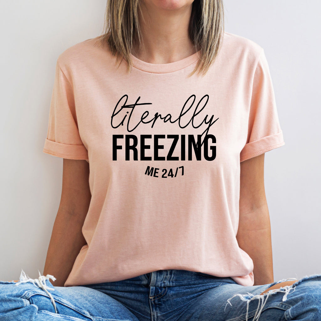 Person wearing a pink t-shirt with 'literally FREEZING me 24/7' text.