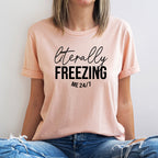 Person wearing a pink t-shirt with 'literally FREEZING me 24/7' text.