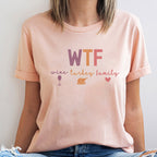 Person wearing a pink t-shirt with colorful text and graphics.
