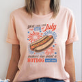 Person wearing a peach t-shirt with a hotdog graphic and text on a white background