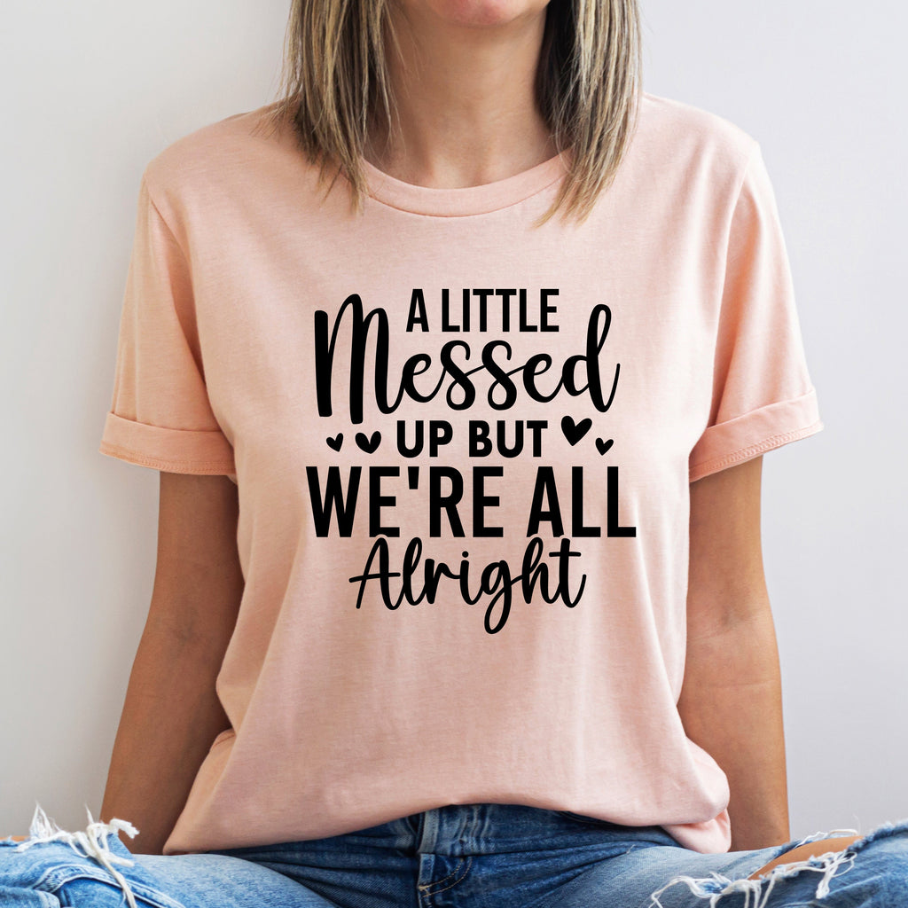 Person wearing a pink t-shirt with a motivational quote on a plain background