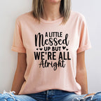 Person wearing a pink t-shirt with a motivational quote on a plain background