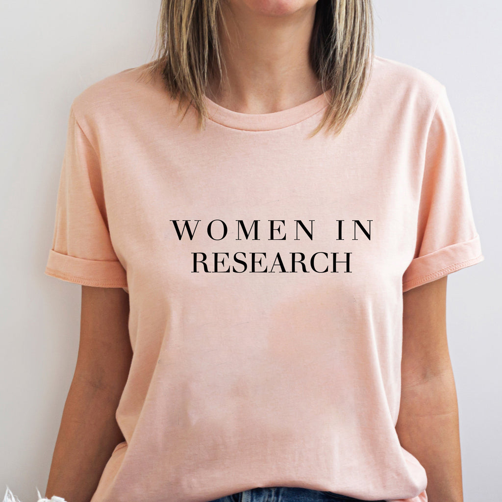 Person wearing a pink t-shirt with 'WOMEN IN RESEARCH' text.