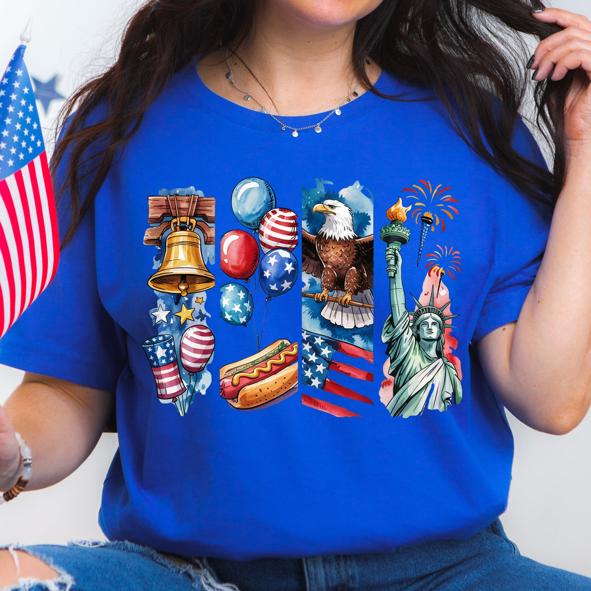 Person wearing a blue t-shirt with American-themed graphics, holding an American flag.