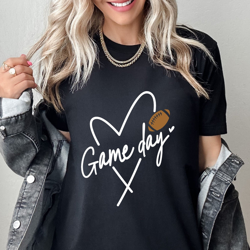 Person wearing a black t-shirt with 'Game day' and heart design, standing against a plain background.