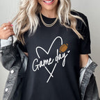 Person wearing a black t-shirt with 'Game day' and heart design, standing against a plain background.