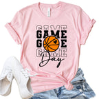 Pink t-shirt with 'Game Day' and basketball graphic, paired with white sneakers and denim shorts on a white background.